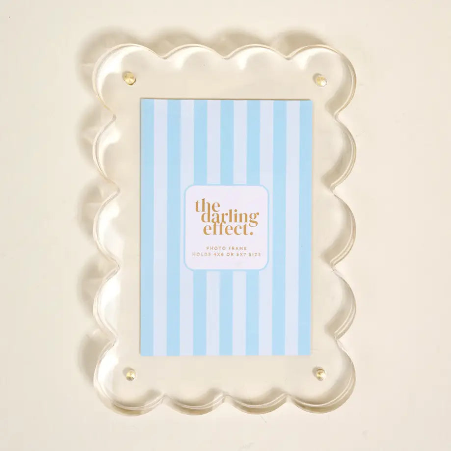 Decorative acrylic photo frame with scalloped edge and 'the darling effect' insert card shown on a light background