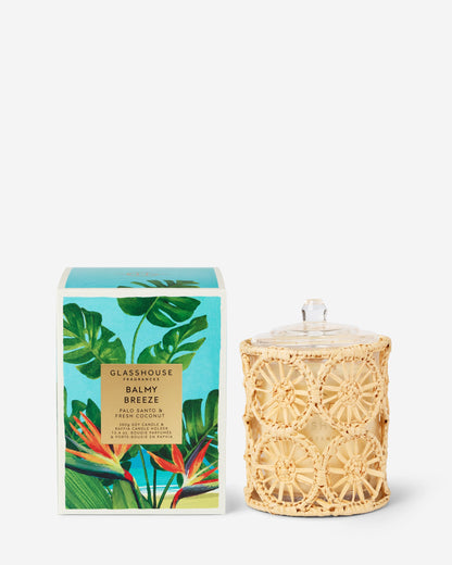 Candle with decorative packaging featuring tropical designs on a white background
