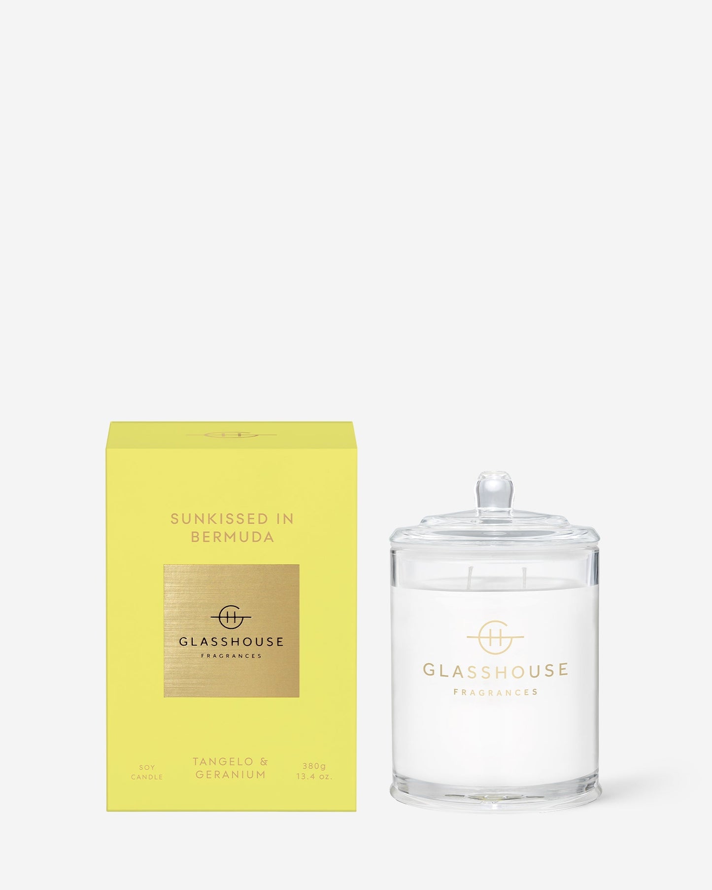  Sunkissed In Bermuda Triple Scented Candle in clear glass vessel set next to tits bright yellow box