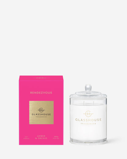  Rendezvous Triple Scented Candle in clear glass vessel set next to its bright pink box