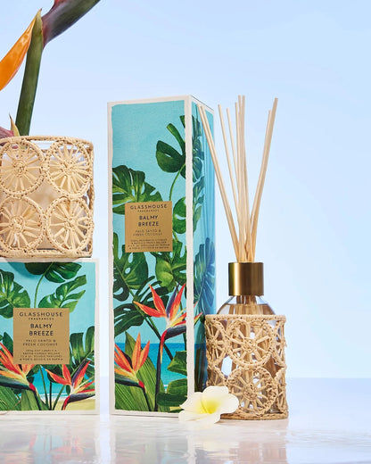 Reed diffuser set with decorative packaging featuring tropical plants on a light blue background.