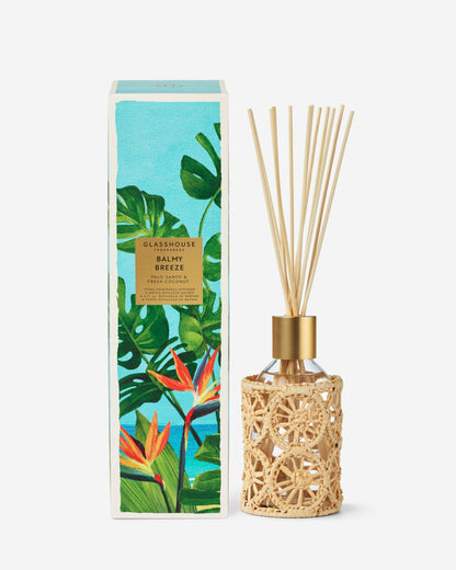 Diffuser with rattan design and decorative packaging featuring tropical plants on a white background