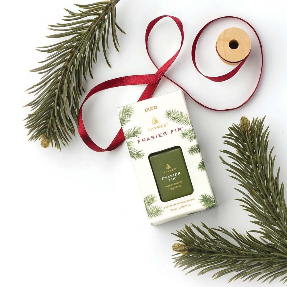 Frasier fir pura refil in its box on a white background with fir stems and red ribbon spool