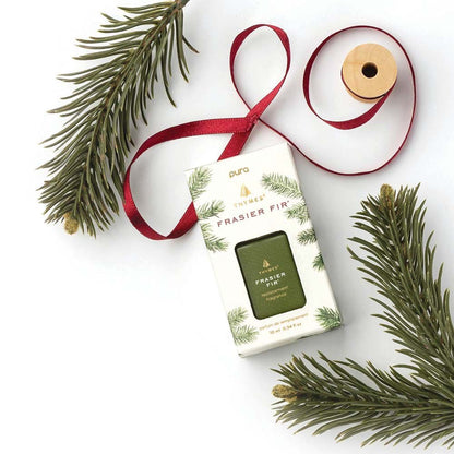 Frasier fir pura refil in its box on a white background with fir stems and red ribbon spool