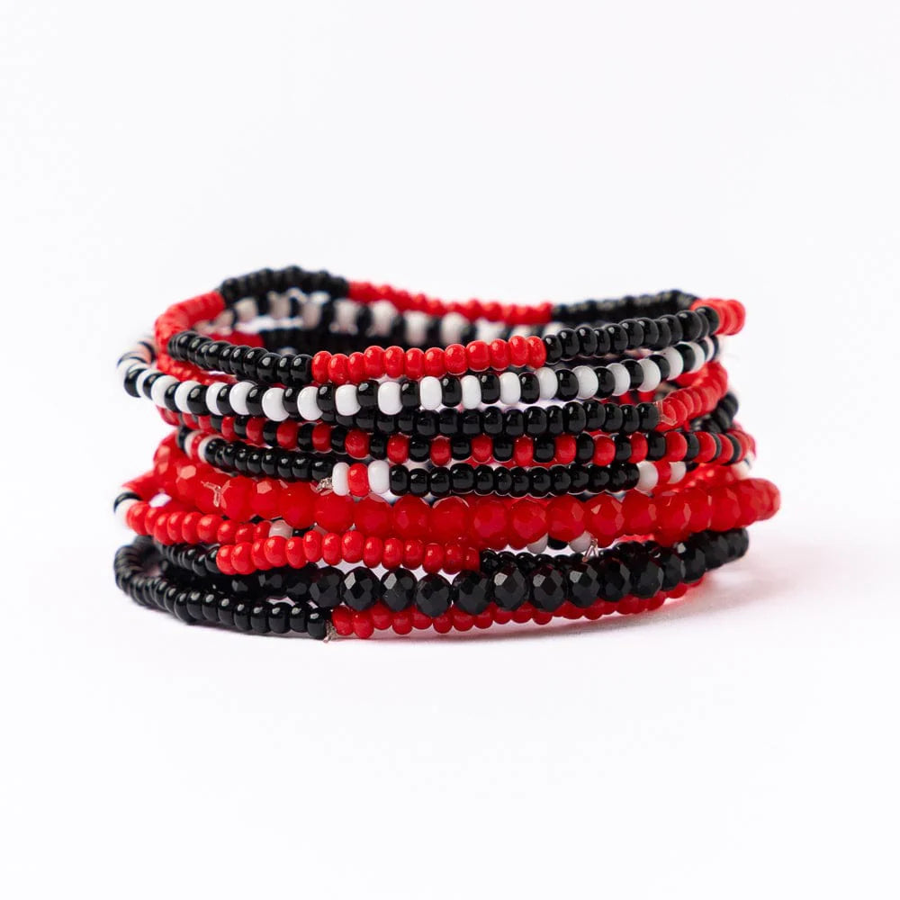 Stack of red, black, and white beaded bracelets on a white background