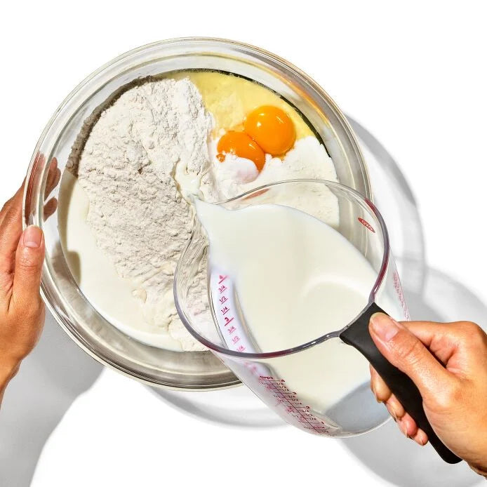 hand pouring batter ingredients in to bowl with Good Grips Angled Measuring Cup