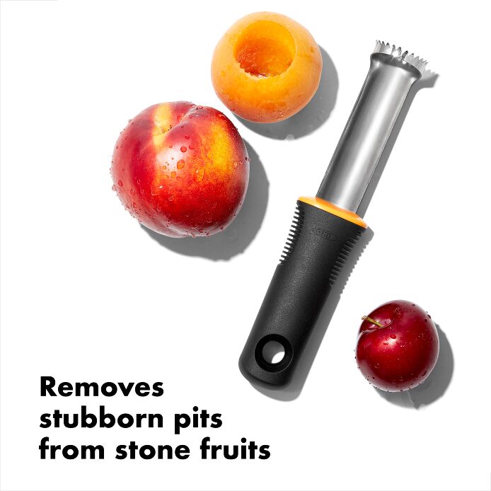 peach pitter arranged on a white background with a peach and other pitted fruits