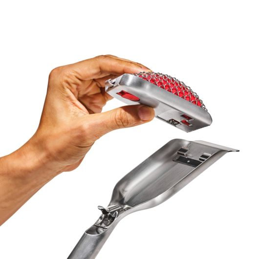 illustration of a mans hand placing a new replacement head on the good grips coiled grill brush against a white background