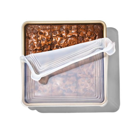 top view of the square Good Grips Silicone Bakeware Lid partially covering baked brownies and displayed against a white background