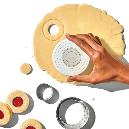 hand using cutter to cut dough.
