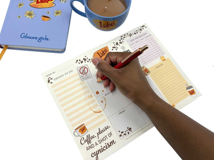 a person filling out their weekly planner notepad