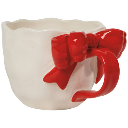 side view of A white ceramic mug with a red sculpted bow tie on the handle