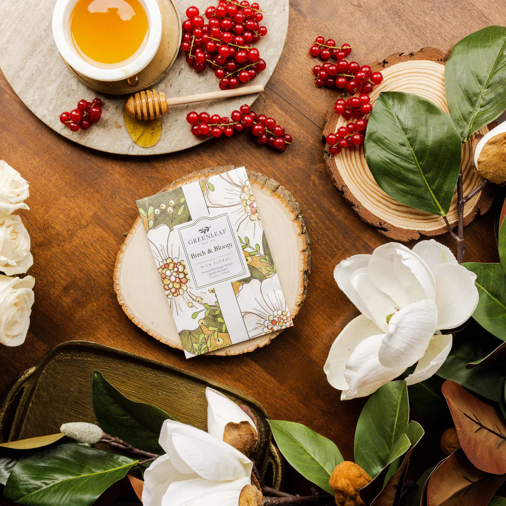 Birch & Bloom Large Sachet laying on a table with greenery, red berries, and honey