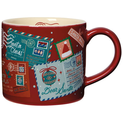 A red Christmas-themed ceramic mug with a design that letters and festive holiday stamps.