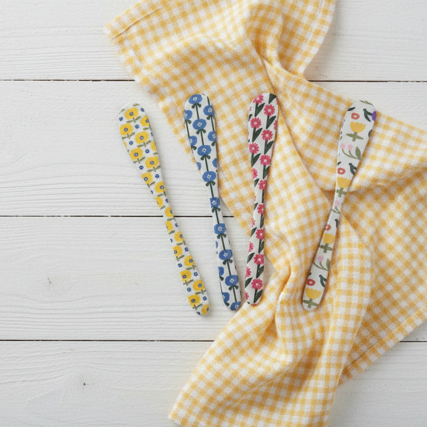 4 spreaders arranged on a wooden surface with a yellow gingham cloth