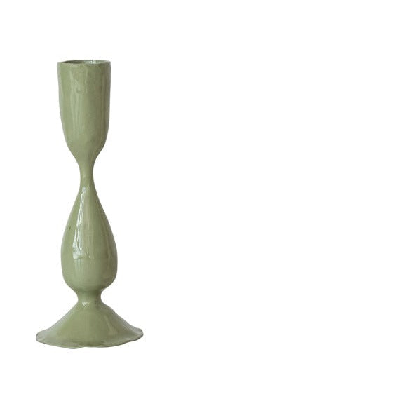 green taper candle holder on a white background