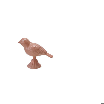 pink metal bird figurine with its head up and tail down