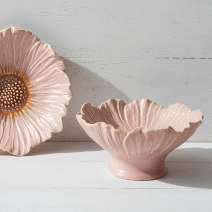 top and side views of pink pedestaled flower shaped bowls next to each other shown on a white wooden background