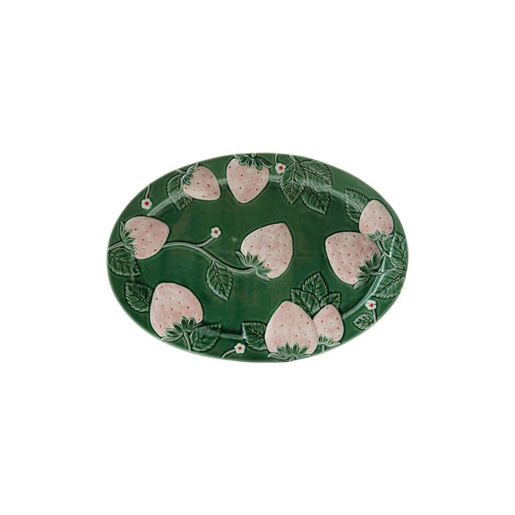 green oval platter with light pink embossed strawberries on it