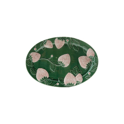 green oval platter with light pink embossed strawberries on it