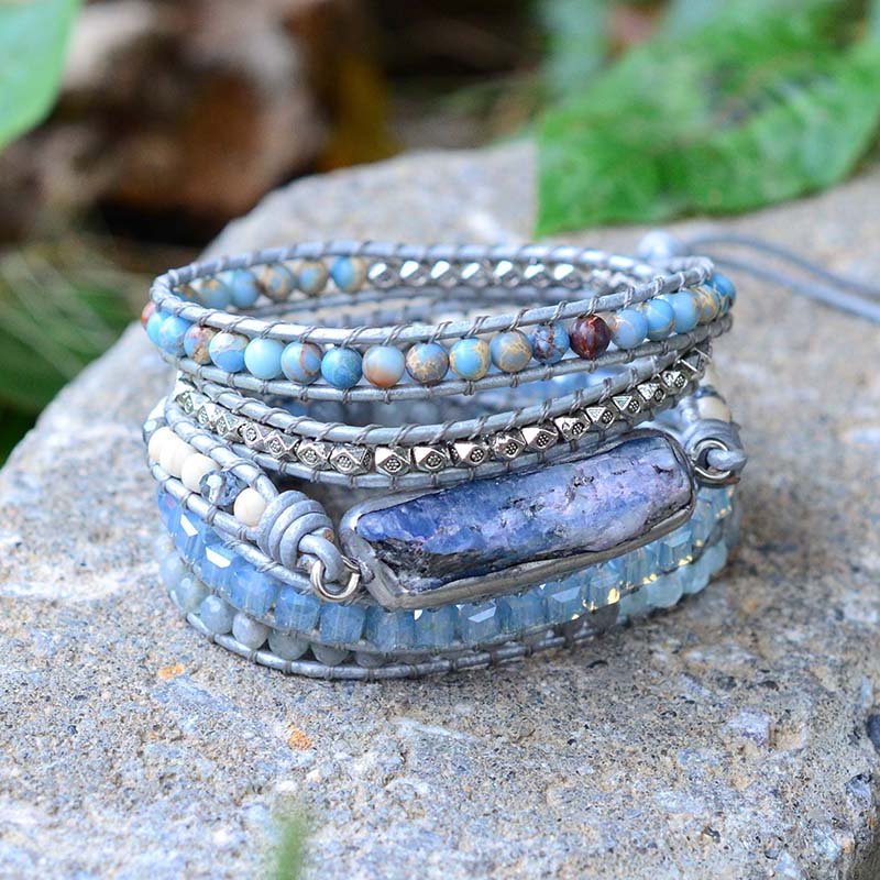 Healing Topaz wrap bracelet arranged on a stone with leaves in the background.
