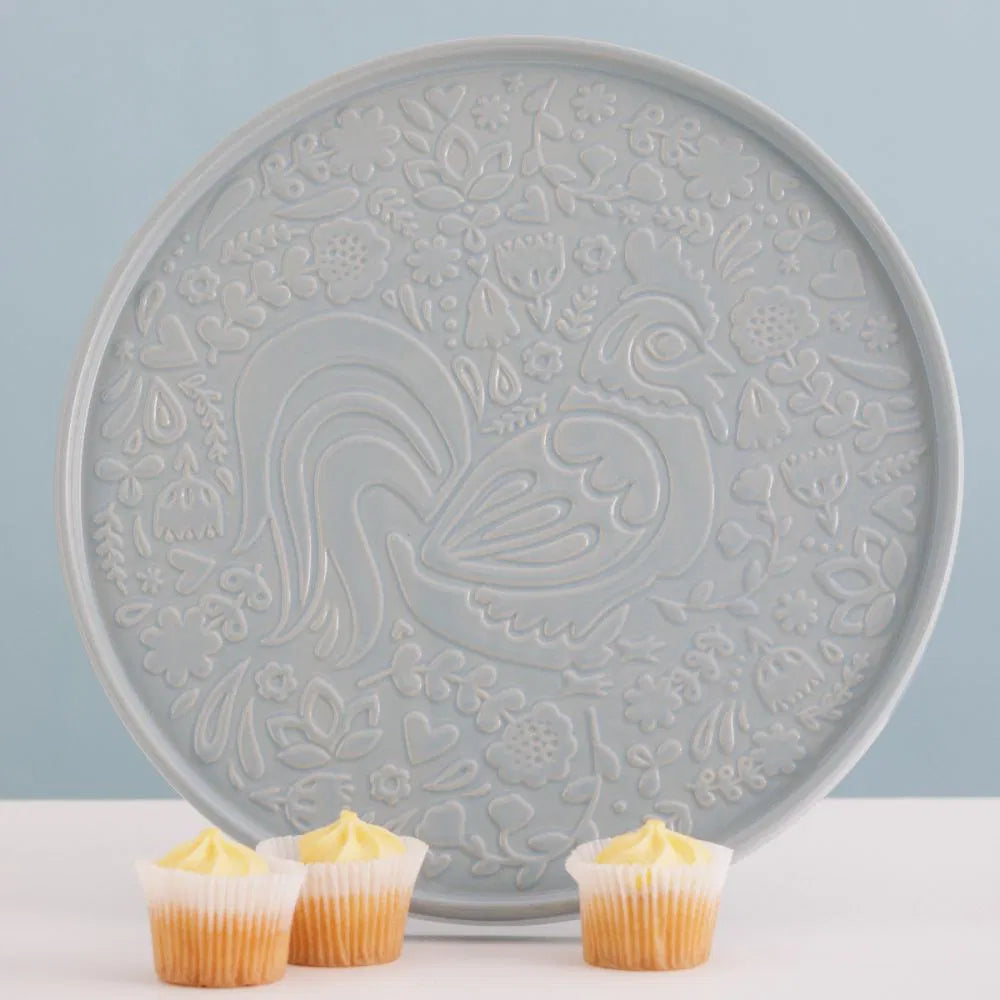 Decorative ceramic platter with embossed chicken and floral design on a light blue background