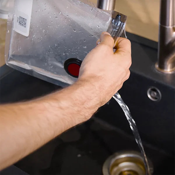 hands washing a Vacuum Bag.