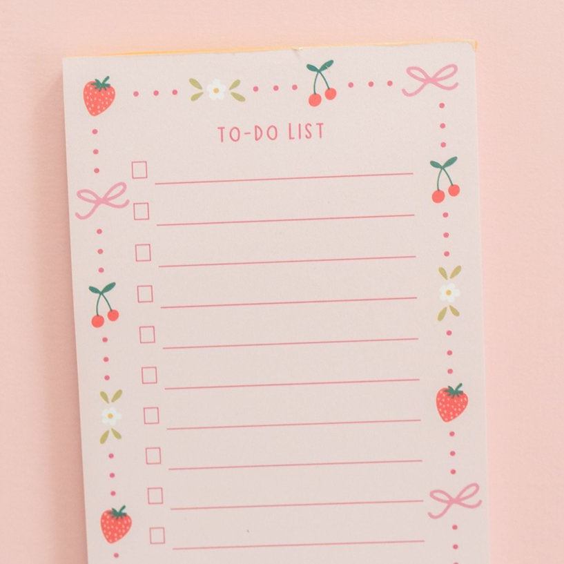 top half of berries and bows to-do notepad on a pink background