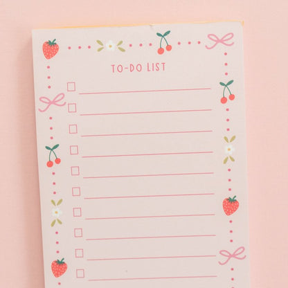 top half of berries and bows to-do notepad on a pink background