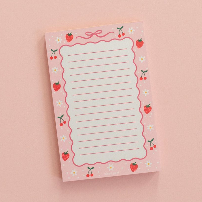 berries and bows notepad on a pink background