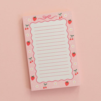 berries and bows notepad on a pink background
