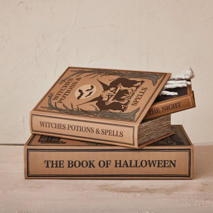 3 book boxes stacked, one is slightly open with a skeleton hand inside