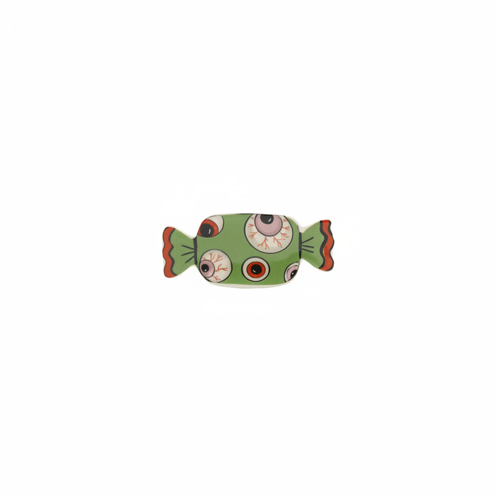 green candy shaped small dish with eyeball pattern on it