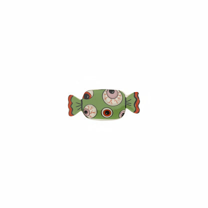 green candy shaped small dish with eyeball pattern on it