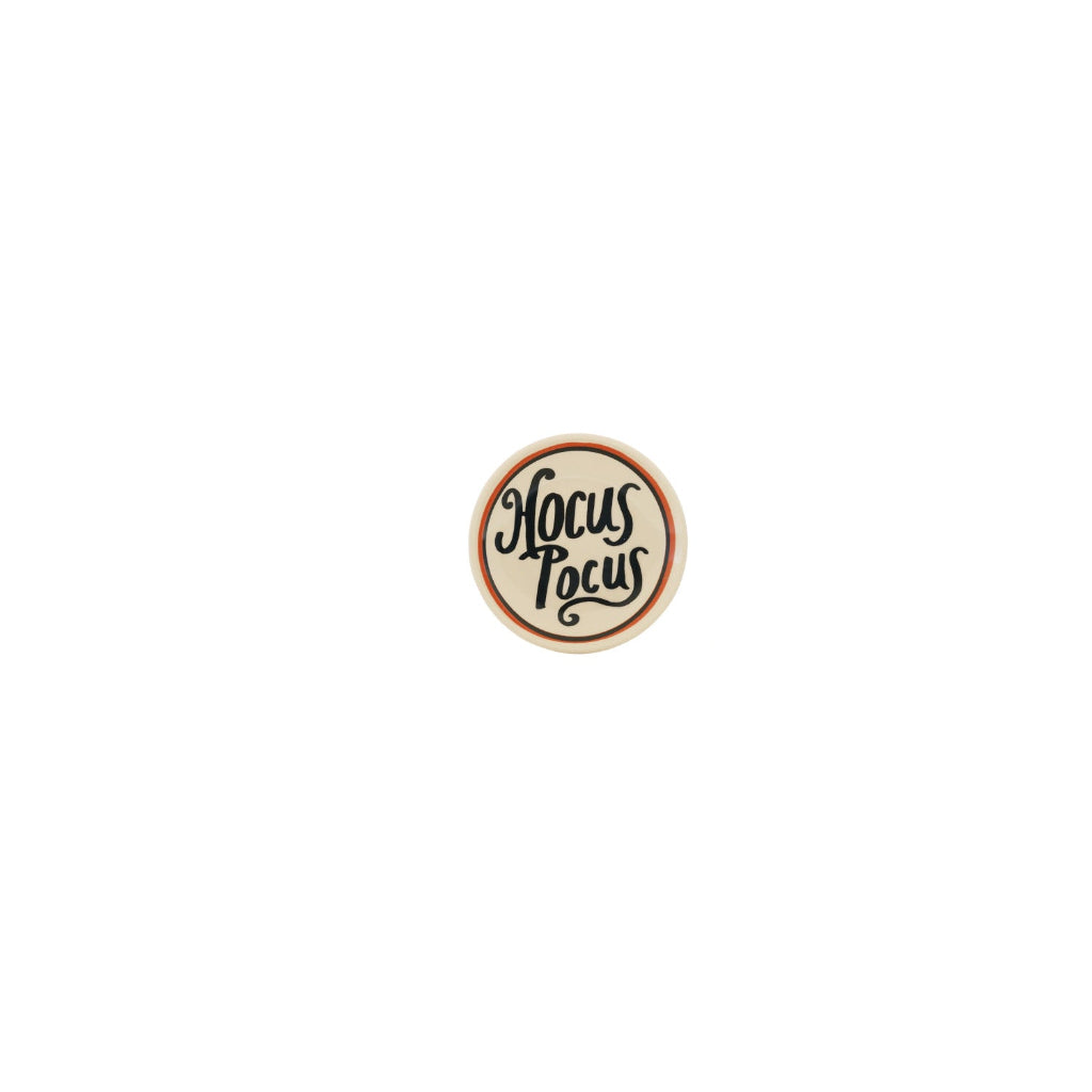 round white trinket tray with "hocus pocus" printed on it in black shown on a white background