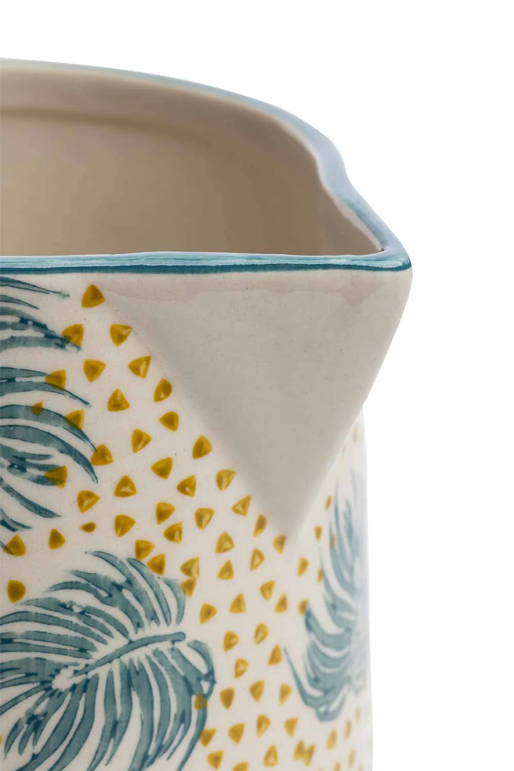 close-up of Ceramic pitcher with tropical leaf and dot pattern on a white background