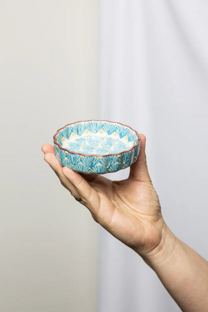 hand holding Blue Art Deco Tartelette Dish in front of a light grey background