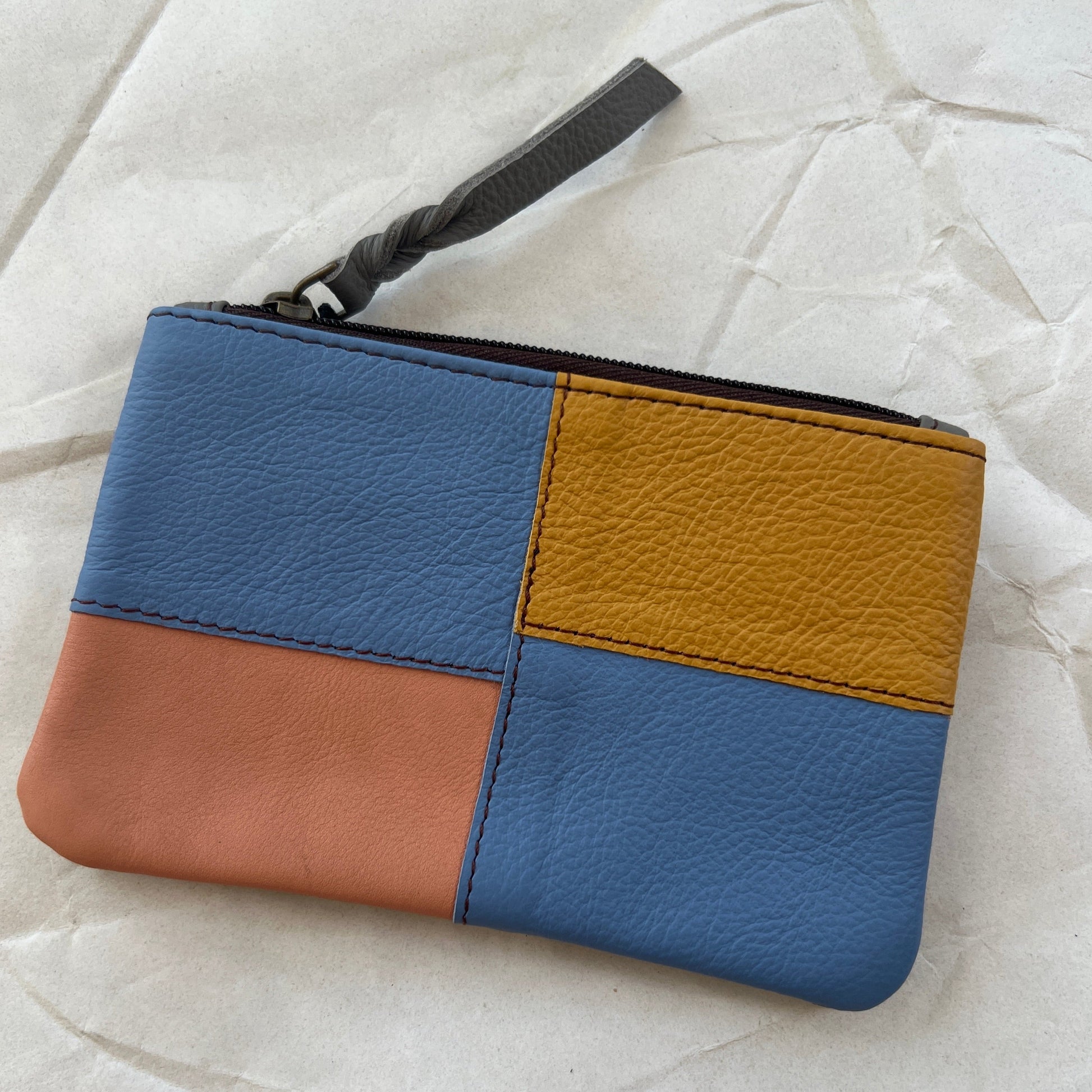 zahra pouch with patchwork in blues and shades of orange.