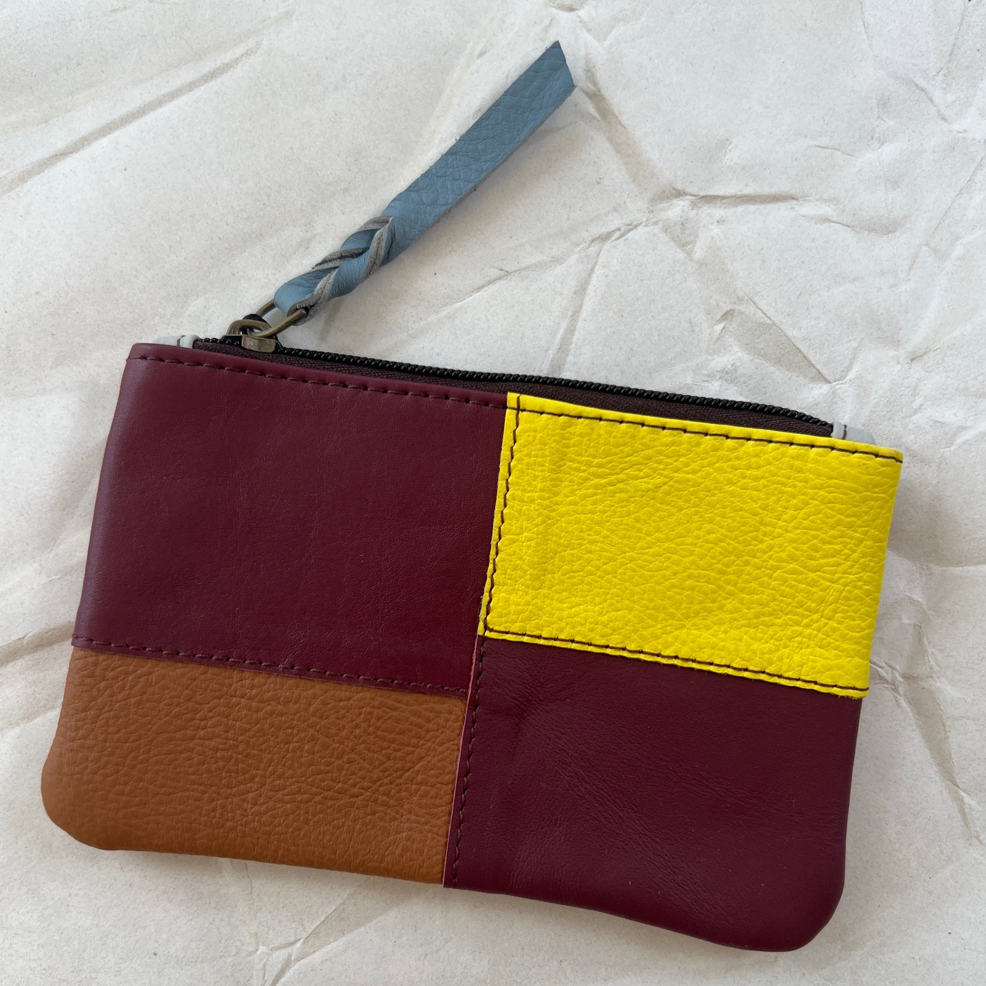 zahra pouch with patchwork in  shades of maroon and yellow.