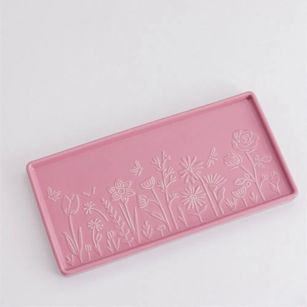 Pink tray with floral embossing on a light gray background