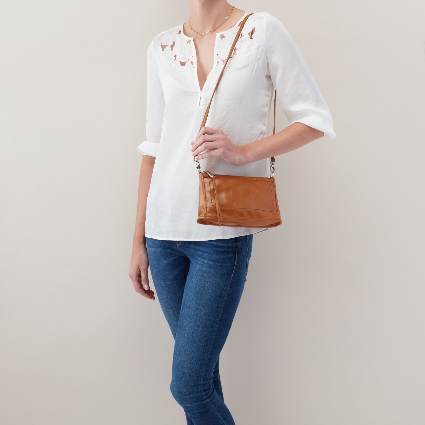 person wearing jeans and a white top with truffle cadence crossbody on their shoulder.