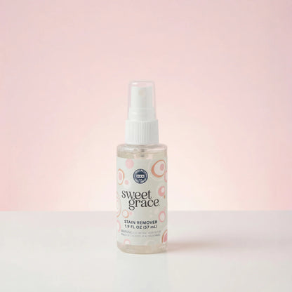 small spray bottle of sweet grace stain remover shown on a pink background