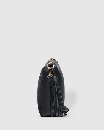 Side view of black Daisy bag with tassel clip to the handle clasp.