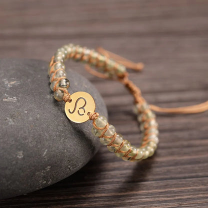 leo bracelet draped on a stone on a wooden table.