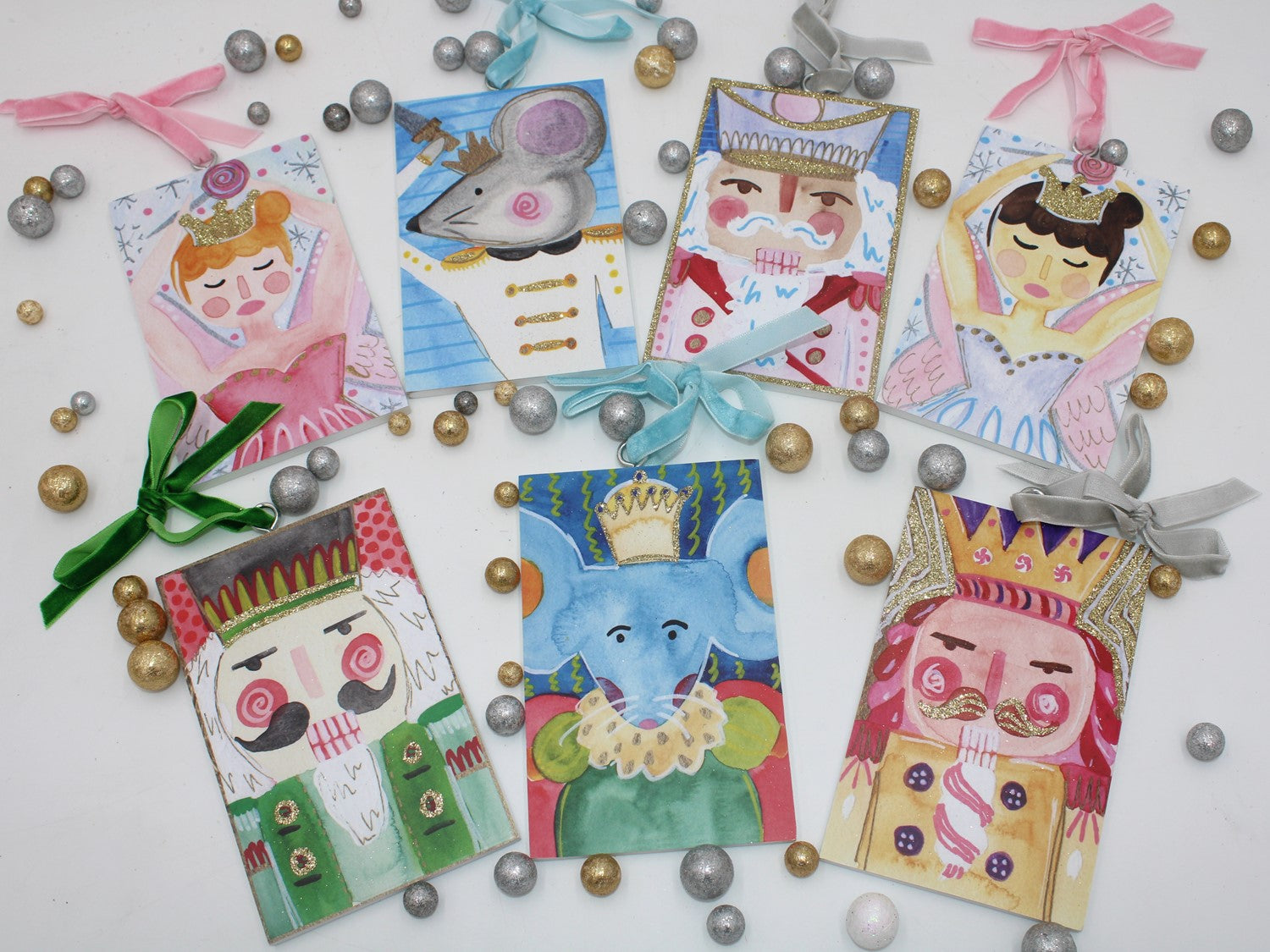 7 assorted ornaments painted with the characters from the nutcracker ballet.