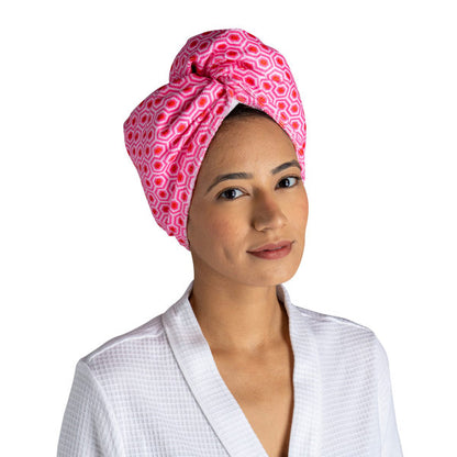 a woman modeling the hot pink geo Plot Twist Microfiber Turbo Towel on her hair against a white background