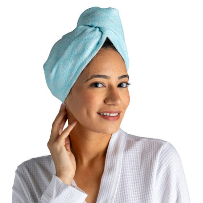 a woman modeling the teal diamonds Plot Twist Microfiber Turbo Towel on her hair against a white background