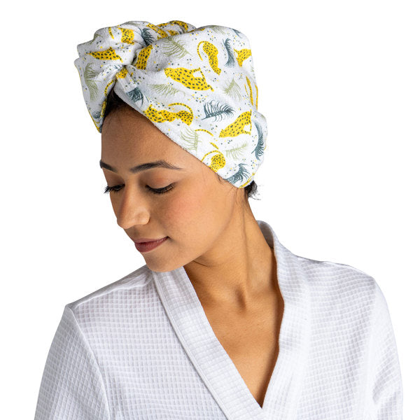 a woman modeling the cheetah Plot Twist Microfiber Turbo Towel on her hair against a white background
