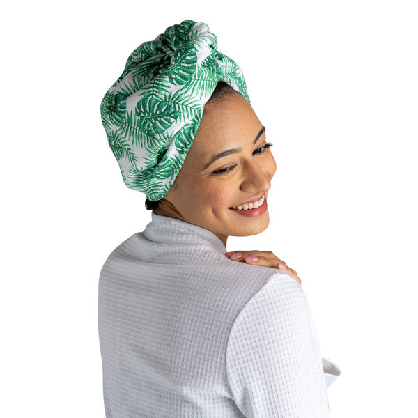 a woman modeling the palm leaves Plot Twist Microfiber Turbo Towel on her hair against a white background