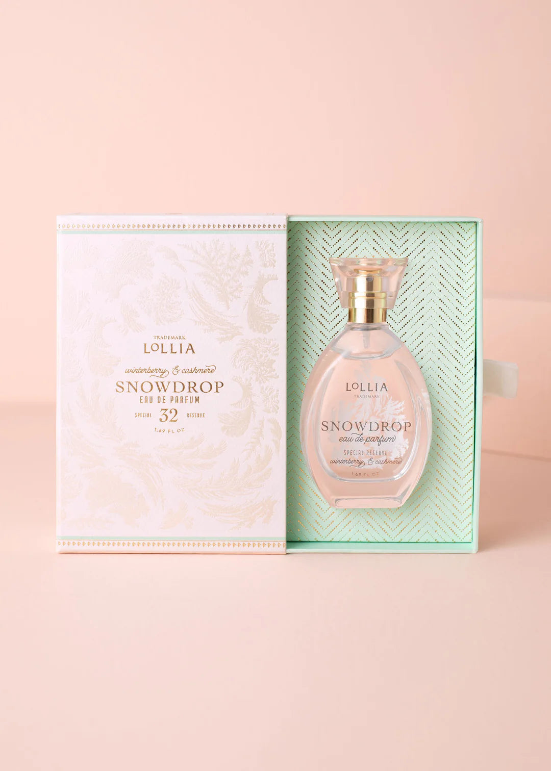 Lollia Snowdrop perfume bottle with packaging on a pink background